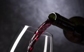 vino rosso versato in un bicchiere in vetro